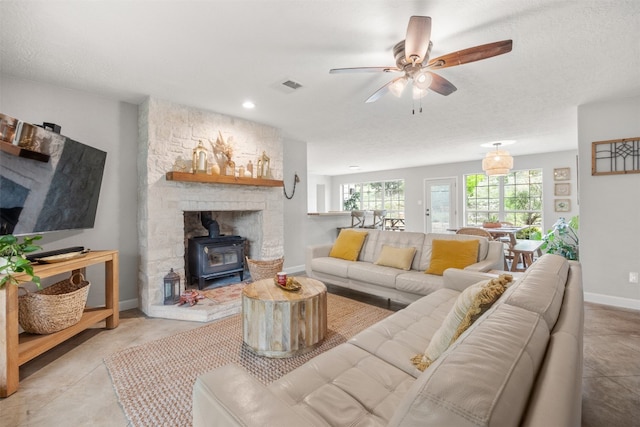 12099 Bonham Ranch Rd, Dripping Springs, TX 78620 - living room with a wood stove, a ceiling fan, and baseboards