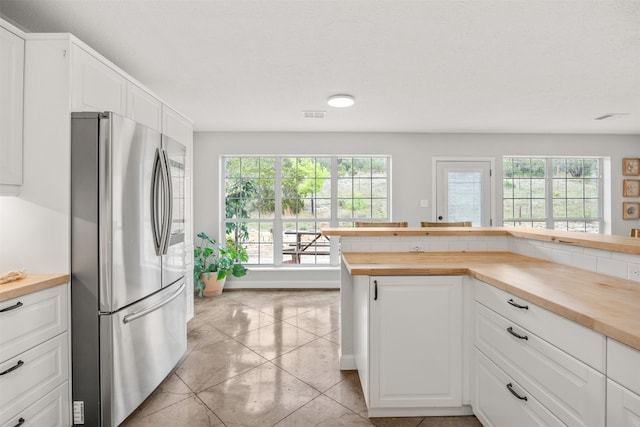 12099 Bonham Ranch Rd, Dripping Springs, TX 78620 - kitchen with freestanding refrigerator, wooden counters, and white cabinetry