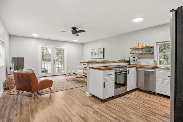 12099 Bonham Ranch Rd, Dripping Springs, TX 78620 - kitchen with stainless steel appliances, white cabinetry, light wood-style floors, wood counters, and a ceiling fan