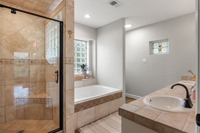 12099 Bonham Ranch Rd, Dripping Springs, TX 78620 - bathroom featuring a garden tub, a stall shower, a textured wall, double vanity, and recessed lighting