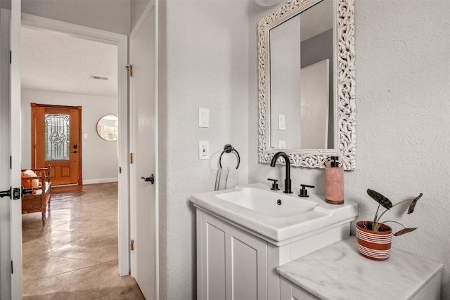 12099 Bonham Ranch Rd, Dripping Springs, TX 78620 - bathroom with a textured wall, vanity, and tile patterned floors
