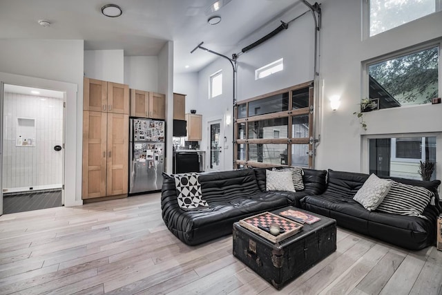 2928 E 13th St Unit B, Austin, TX 78702 - living room featuring light wood-type flooring, a healthy amount of sunlight, and a towering ceiling