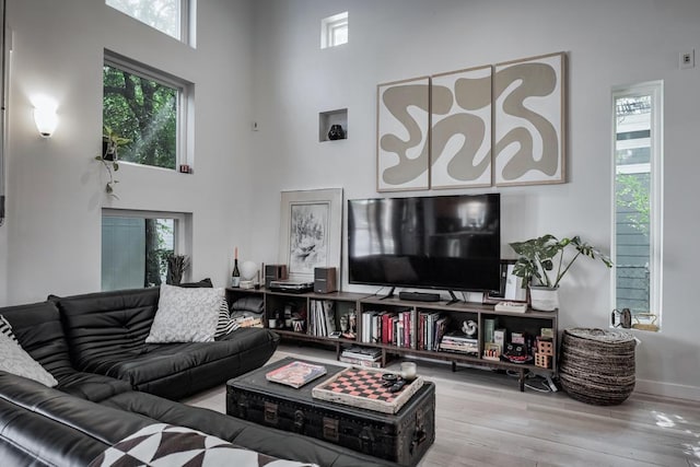 2928 E 13th St Unit B, Austin, TX 78702 - living room featuring wood finished floors, a high ceiling, and plenty of natural light