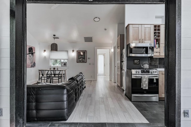 2928 E 13th St Unit B, Austin, TX 78702 - kitchen with baseboards, appliances with stainless steel finishes, wood finished floors, and visible vents