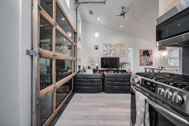 2928 E 13th St Unit B, Austin, TX 78702 - kitchen featuring stainless steel appliances, wood finished floors, visible vents, a ceiling fan, and high vaulted ceiling