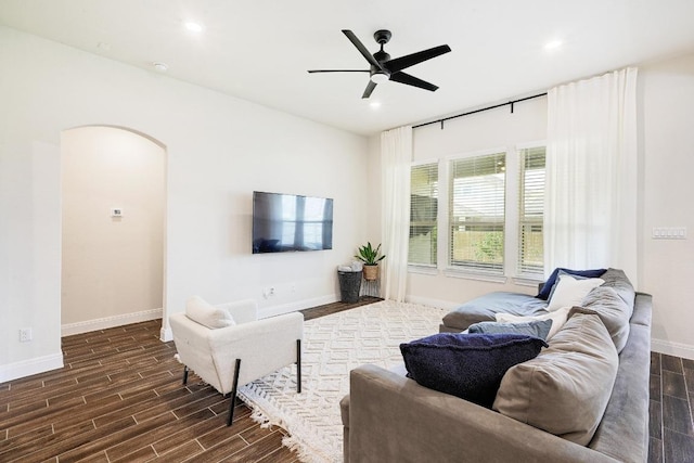 living room with a ceiling fan, dark wood-style floors, and baseboards
