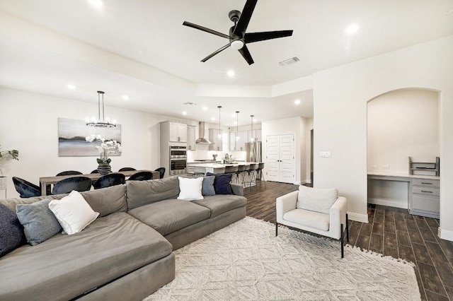 living area featuring visible vents, arched walkways, ceiling fan with notable chandelier, and recessed lighting