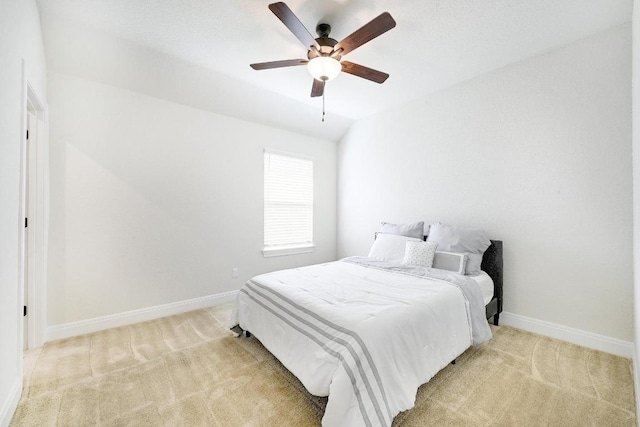 bedroom featuring baseboards, ceiling fan, lofted ceiling, and light colored carpet