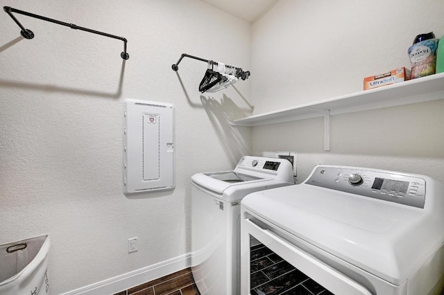 washroom with washing machine and clothes dryer, electric panel, laundry area, and baseboards