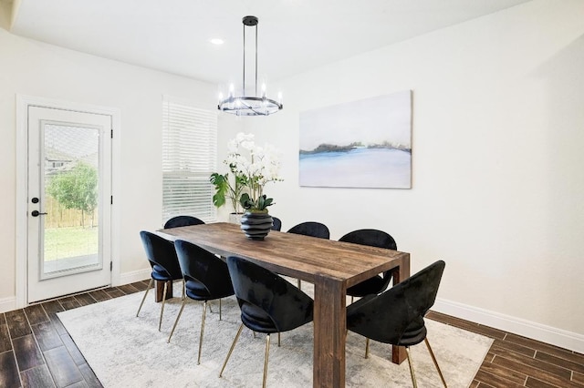 dining area featuring an inviting chandelier, wood finished floors, and baseboards