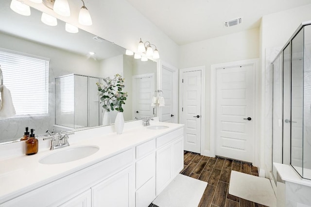 full bath with visible vents, a stall shower, and a sink