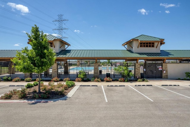 exterior space featuring fence, uncovered parking, and a community pool