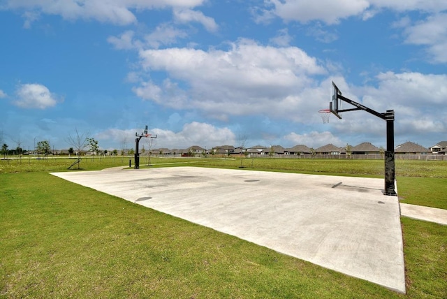 view of sport court featuring fence, community basketball court, a yard, and a residential view