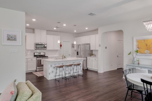 kitchen with appliances with stainless steel finishes, white cabinetry, light countertops, dark wood-style flooring, and recessed lighting