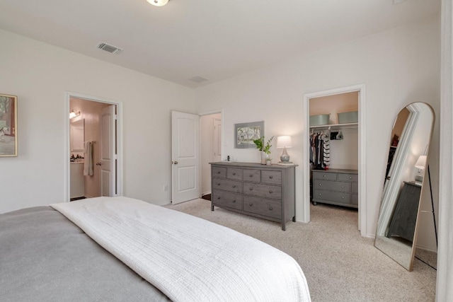 1617 Uhland Dr, Leander, TX 78641 - bedroom featuring a spacious closet, light carpet, a closet, ensuite bath, and arched walkways
