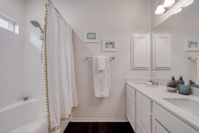 full bathroom featuring double vanity, shower / tub combo, and wood finished floors