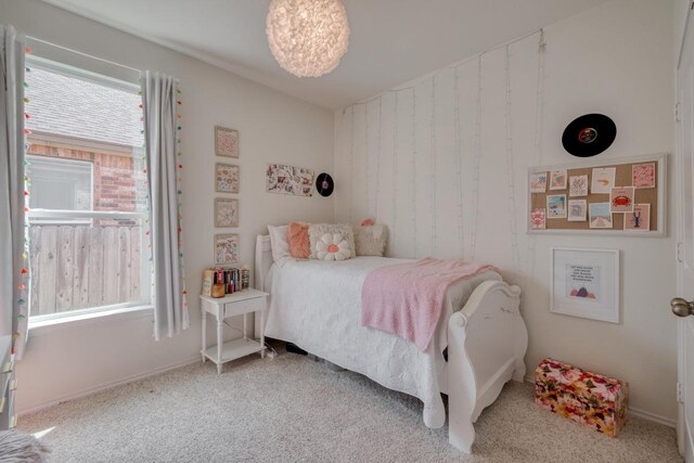carpeted bedroom featuring multiple windows and baseboards