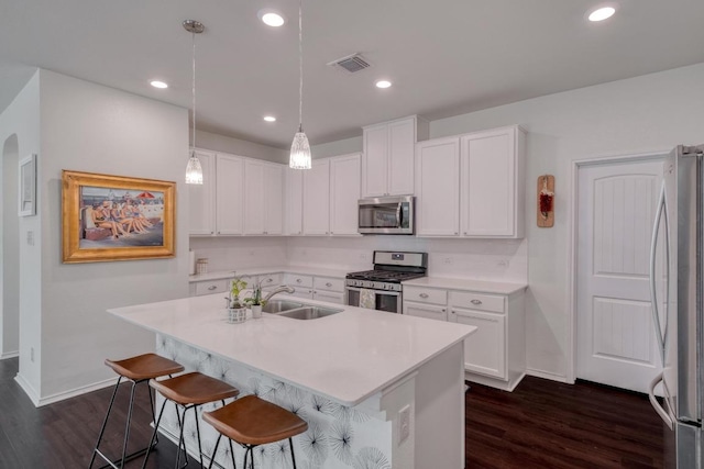 kitchen with stainless steel appliances, dark wood-style flooring, a sink, white cabinetry, and recessed lighting