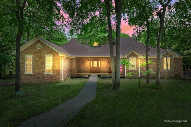 view of front of property with brick siding, roof with shingles, crawl space, and a front lawn