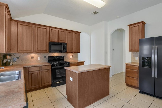 1901 Rachel Ln, Round Rock, TX 78664 - kitchen featuring black appliances, arched walkways, decorative backsplash, light tile patterned flooring, and a center island