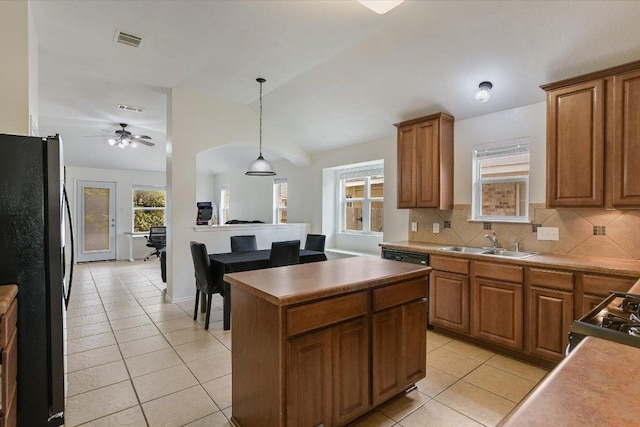 1901 Rachel Ln, Round Rock, TX 78664 - kitchen with freestanding refrigerator, a sink, light tile patterned flooring, vaulted ceiling, and brown cabinetry