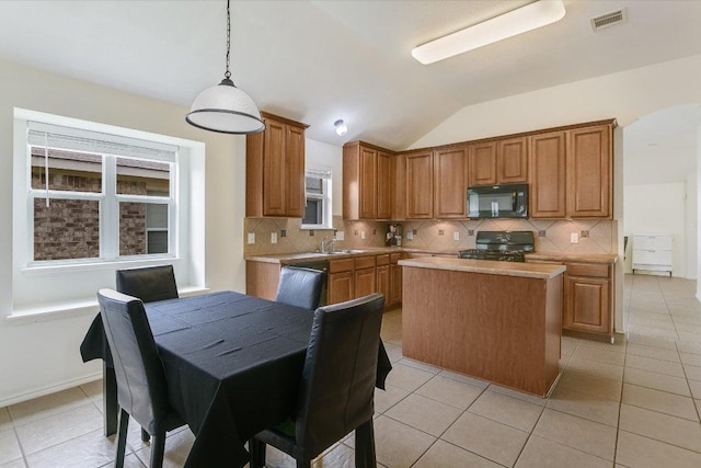 1901 Rachel Ln, Round Rock, TX 78664 - kitchen with black microwave, range, vaulted ceiling, a sink, and a center island