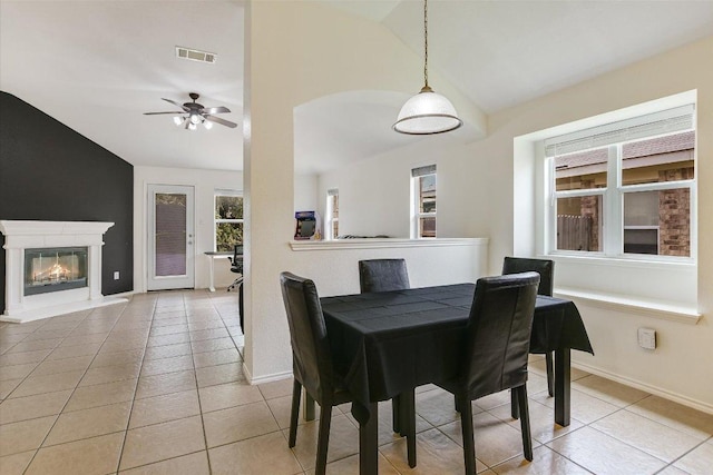 1901 Rachel Ln, Round Rock, TX 78664 - dining area with lofted ceiling, light tile patterned floors, baseboards, a glass covered fireplace, and ceiling fan