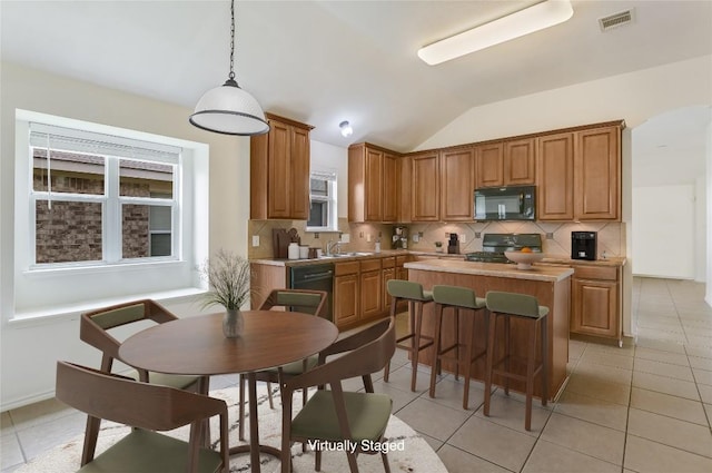 1901 Rachel Ln, Round Rock, TX 78664 - kitchen with black appliances, a kitchen island, backsplash, lofted ceiling, and pendant lighting