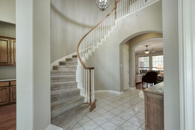 3803 Bobby Jones Way, Round Rock, TX 78664 - staircase with ceiling fan, arched walkways, tile patterned flooring, and a chandelier