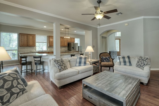 3803 Bobby Jones Way, Round Rock, TX 78664 - living room featuring arched walkways, dark wood finished floors, ceiling fan, ornamental molding, and recessed lighting