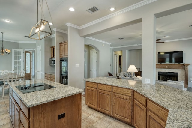 3803 Bobby Jones Way, Round Rock, TX 78664 - kitchen with open floor plan, a chandelier, black appliances, a fireplace, and light stone countertops
