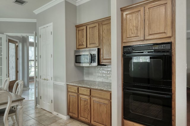 3803 Bobby Jones Way, Round Rock, TX 78664 - kitchen featuring stainless steel microwave, decorative backsplash, ornamental molding, light tile patterned floors, and light stone countertops