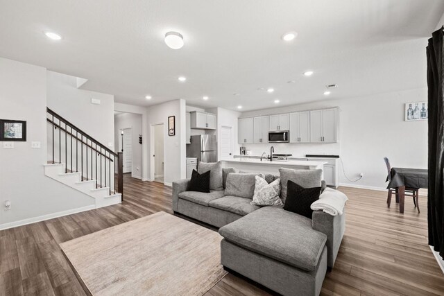 17717 Zinfandel Dr, Pflugerville, TX 78660 - living area with recessed lighting, light wood-style flooring, baseboards, and stairway