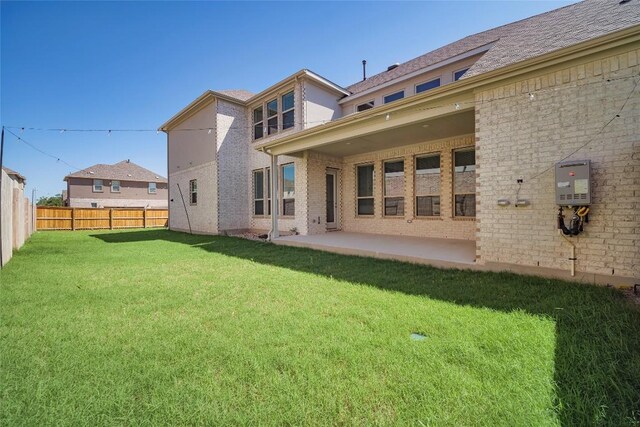 3049 Sage Ranch Dr, Leander, TX 78641 - back of house with a patio area, brick siding, and water heater