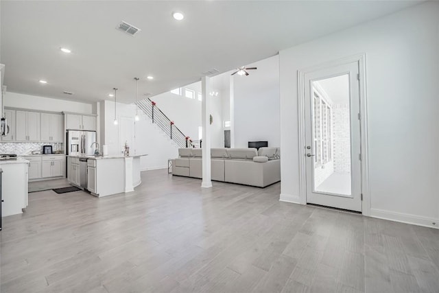 3049 Sage Ranch Dr, Leander, TX 78641 - living room featuring light wood-type flooring, recessed lighting, and stairs