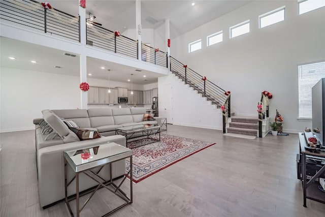 3049 Sage Ranch Dr, Leander, TX 78641 - living area with a towering ceiling, light wood-style flooring, and stairway