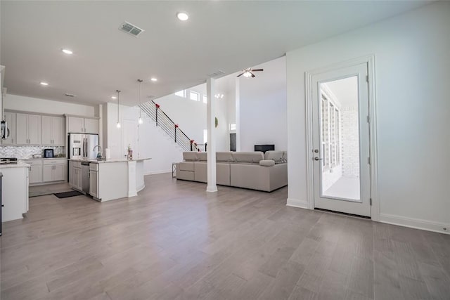 3049 Sage Ranch Dr, Leander, TX 78641 - living room featuring light wood-type flooring, recessed lighting, stairway, and ceiling fan