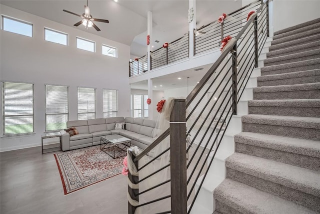 3049 Sage Ranch Dr, Leander, TX 78641 - living room featuring a towering ceiling, wood finished floors, a ceiling fan, and stairs