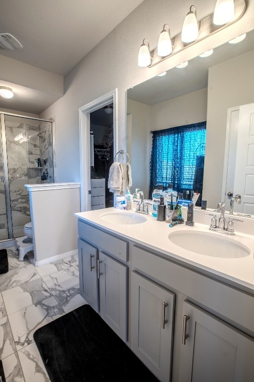 10516 Alemoor Dr, Austin, TX 78747 - full bathroom with double vanity, a stall shower, toilet, and marble look tile flooring