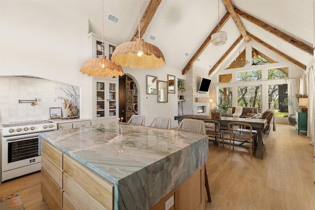 kitchen with stainless steel electric stove, visible vents, high vaulted ceiling, and beamed ceiling