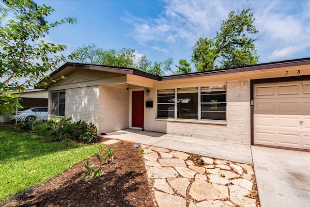 ranch-style home featuring an attached garage, brick siding, driveway, and a front lawn