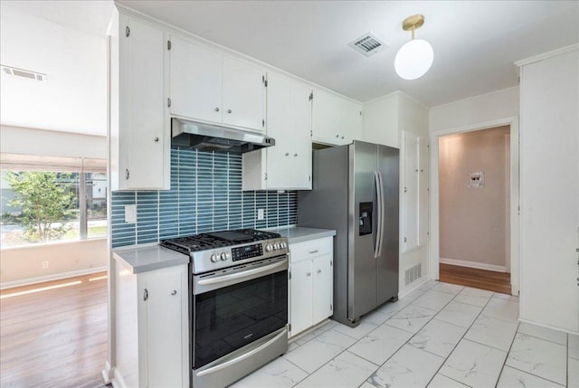 kitchen featuring visible vents, appliances with stainless steel finishes, baseboards, and under cabinet range hood