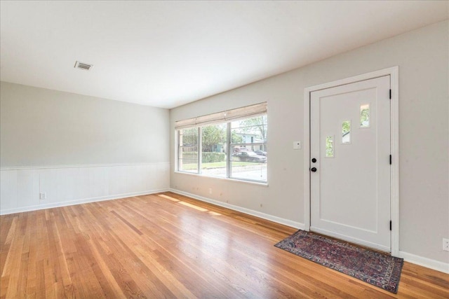foyer entrance featuring baseboards, visible vents, and light wood-style floors