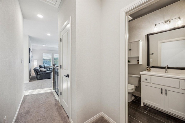 bathroom with recessed lighting, vanity, toilet, and baseboards