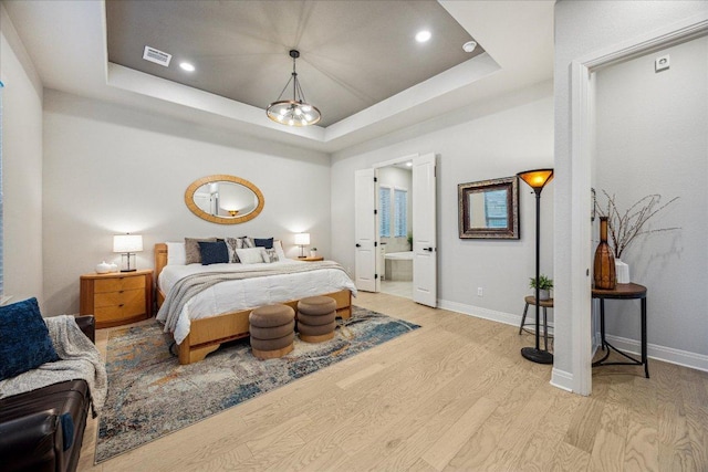 bedroom with light wood-type flooring, baseboards, visible vents, recessed lighting, and a raised ceiling
