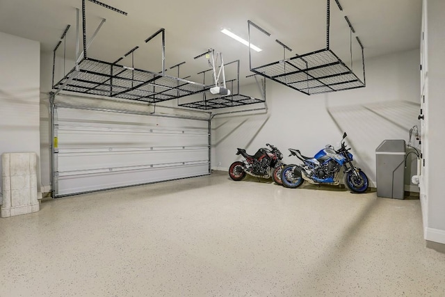 garage with baseboards and a garage door opener