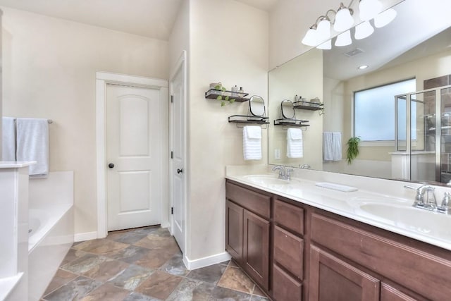 110 Chestnut Ct, Georgetown, TX 78633 - full bathroom with baseboards, a bath, double vanity, stone finish flooring, and a shower with door