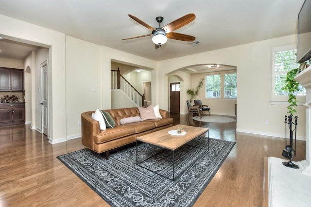 110 Chestnut Ct, Georgetown, TX 78633 - living room with arched walkways, a ceiling fan, stairs, wood finished floors, and baseboards