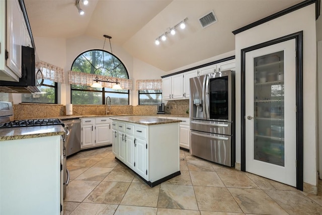 3403 NW Blvd, Georgetown, TX 78628 - kitchen featuring stainless steel appliances, rail lighting, backsplash, white cabinets, and high vaulted ceiling