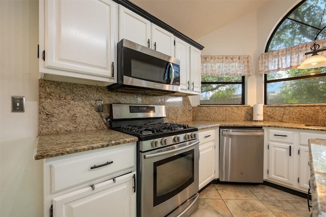 3403 NW Blvd, Georgetown, TX 78628 - kitchen with appliances with stainless steel finishes, tasteful backsplash, vaulted ceiling, white cabinetry, and healthy amount of natural light